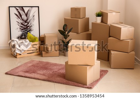 Moving boxes with belongings in empty room