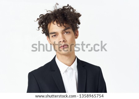 Curly hair black jacket white shirt in a light background handsome man                        