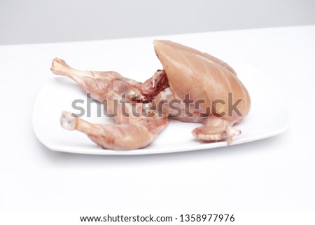 Fresh raw chicken on plate isolated on white background - Stock Photo