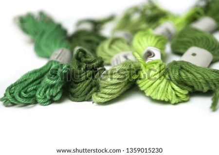 closeup of green cotton threads on white background