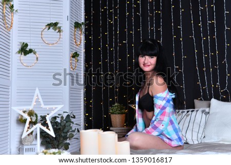 portrait of brunette girl in bed on the background of New Year decorations