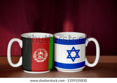 Israel and Afghanistan flag on two cups with blurry background