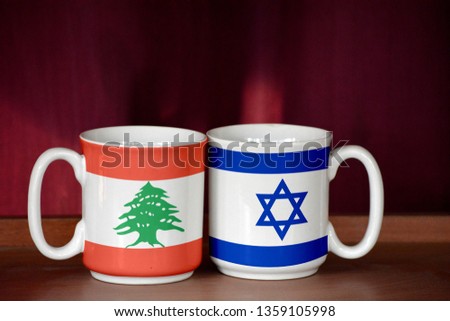 Israel and Lebanon flag on two cups with blurry background