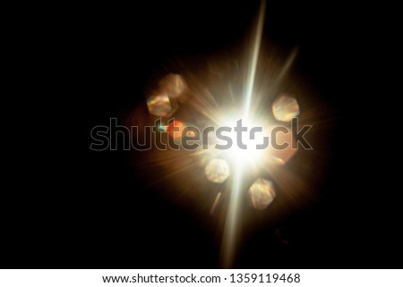 Lens Flare. Light over black background. Easy to add overlay or screen filter over photos. Abstract sun burst with digital lens flare background. Gleams rounded and hexagonal shapes, rainbow halo.