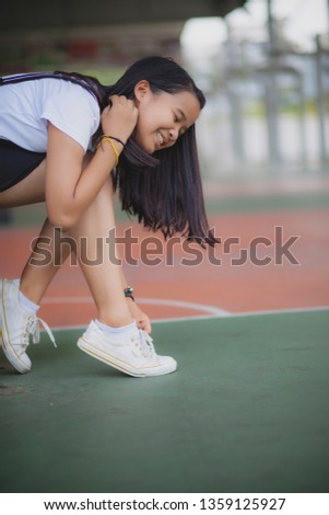 asian teenager wearing sneaker shoe in indoor sport club