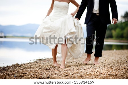 Bride and groom are walking outside together Royalty-Free Stock Photo #135914159