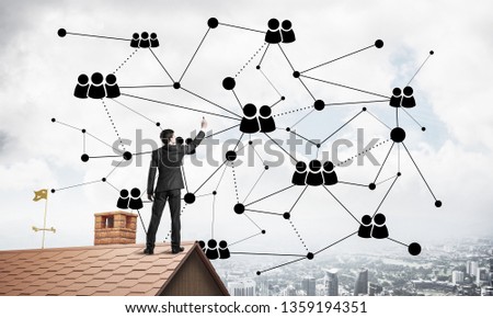 Young man standing with back on roof and drawing connection lines. Mixed media