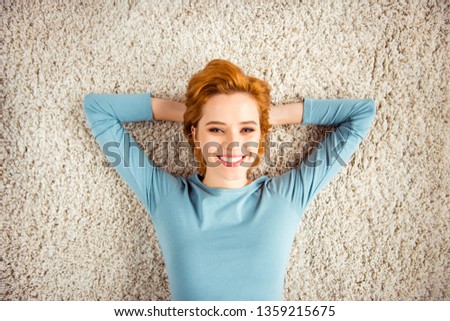 Close up photo amazing beautiful she her lady hands arms behind head sleep white teeth red short hairdo wear blue pullover jeans denim clothes lying carpet floor divan house loft living room indoors