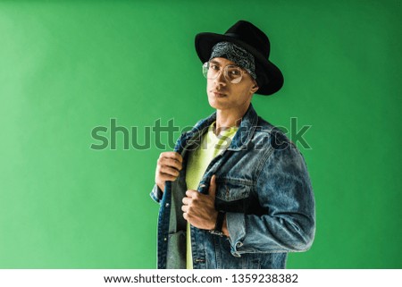 stylish mixed race man posing and looking at camera on green screen with copy space