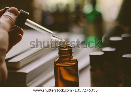 Taking drops from a tincture herbal remedy bottle, close up . vintage filter  Royalty-Free Stock Photo #1359276335