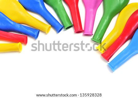a pile of uninflated balloons of different colors on a white background