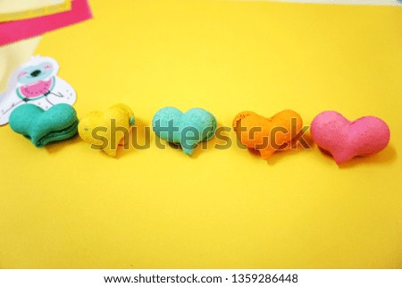 sweet heart macaron, blue, yellow, orange, pink macarons with sloth cartoon and watermelon, macarons on yellow background