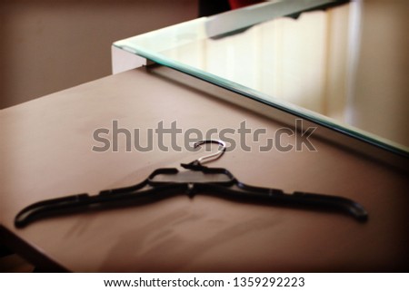 black insulated plastic coat hanger on a brown table