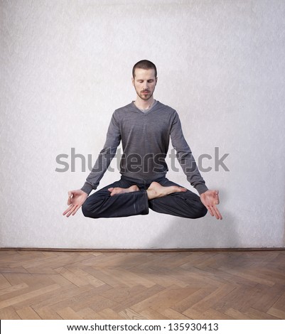 young man levitating in yoga position, meditation