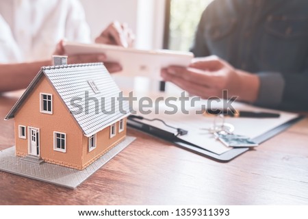 Car and House model with agent and customer discussing for contract to buy, get insurance or loan real estate or property background. Royalty-Free Stock Photo #1359311393