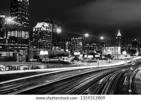 Atlanta, USA. Illuminated Midtown in Atlanta, USA at night. Car traffic, illuminated buildings and dark sky. Car traffic trails. Black and white