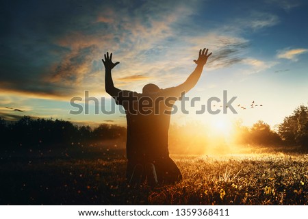 Grateful man man raising his hands in worship in the countryside. Royalty-Free Stock Photo #1359368411
