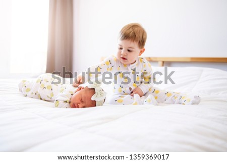 A Little brother with her newborn baby Toddler kid meeting new sibling