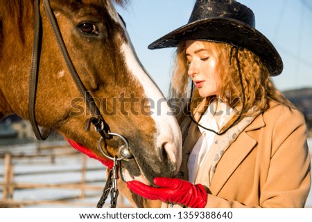 blonde in cowboy hat and brown horse