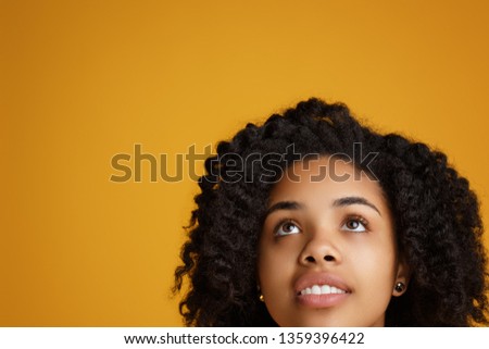 Portrait of attractive african american young woman with beautiful smile dressed in casual clothes over yellow background.