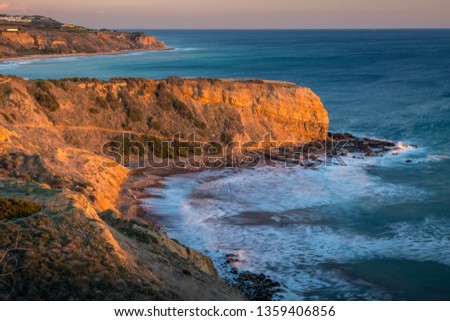 Long exposure photo of Inspiration Point cliff at sunset with waves crashing onto the rocks below Abalone Cove Shoreline Park, Rancho Palos Verdes, California