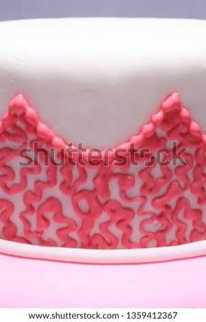 Decorated Cake: two tiers pink and white cake, with ruffles decoration and edible lily flower made from sugar paste - details of the cornelli lace pattern