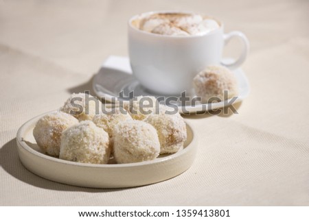 Tasty Sweets Covered with Coconut Chips. Handmade Candies and Cup of Coffee with Marshmallow on Dark Background. Tasty Luxury Dessert