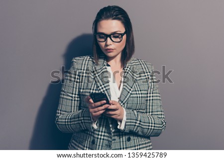 Portrait of confident focused concentrated looking at cellular attractive with bob haircut she her lady user isolated grey background