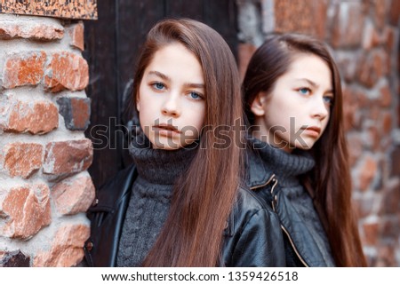 Twins sisters outside in autumn. Fashion look