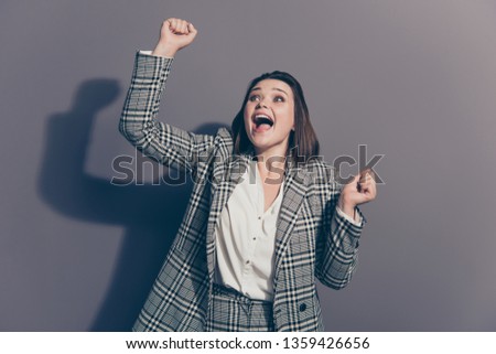 Close up photo portrait of cheerful funky funny glad winning prize with opened mouth lady holding raising fists up isolated grey background