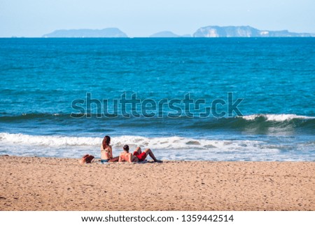 A couple are enjoying with the sun and a sea on the beach..