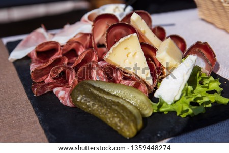 Picture of a plate of speck and typical italian salami with cheese and pickles, Cortina D'Ampezzo, Italy