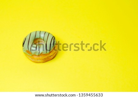 green chocolate donut on yellow background and space for your advertising. retro style background.Collection for celebration design.Sweet dessert