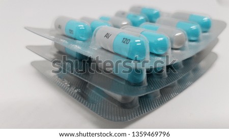 3 sealed packets of blue and grey tablets stacked on top of each other.