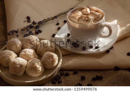 Coconut Sweets with Morning Coffee. Handmade Candies and Cup of Coffee with Marshmallow on Fabrics Background. Tasty Luxury Dessert