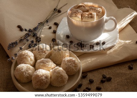Coconut Sweets with Morning Coffee. Handmade Candies and Cup of Coffee with Marshmallow on Fabrics Background. Tasty Luxury Dessert