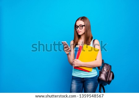 Close up photo beautiful amazing she her lady hold study applies back bag shoulder telephone hand arm curious interested reader wear specs casual jeans denim tank top clothes isolated blue background