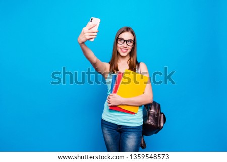 Close up photo beautiful amazing she her lady hold study applies back bag telephone hand arm make take selfies speak talk skype wear specs casual jeans denim tank top clothes isolated blue background