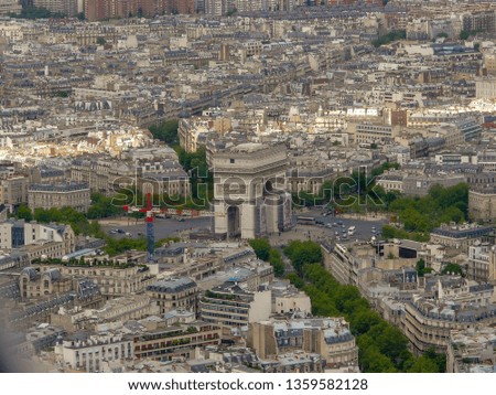 Panoramic aerial view of Paris, France from Eiffel Tower on a sunny day with famous landmarks and La Défense business district. Beautiful wide view of the capital of France, Paris with a cloudy sky.
