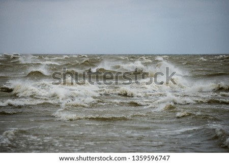 storm weather on the beach by rocky sea shore in latvia. sunset on the rocks with high waves