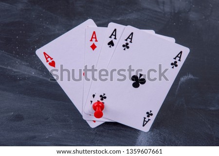 four playing cards all aces on a board