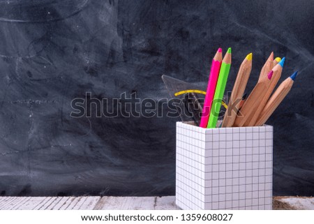 Coloured pencils with blackboard