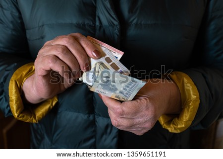 Older senior woman holds EURO banknotes - Eastern European salary pension