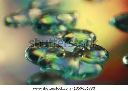 Water drops with glitter and shimmer on mirror cause light interference and refraction effect, color diffraction. Iridescent blurred holographic surface with liquid fluid stains.