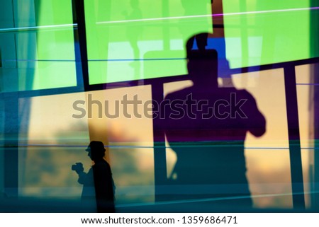 Silhouettes of two photographers reflecting in colorful windows