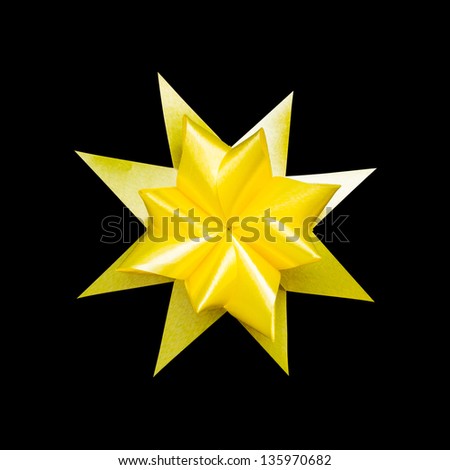 yellow ribbon flower made with folded hands on black background with clipping path
