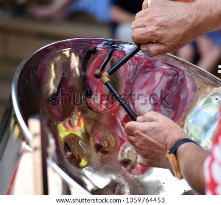 Caribbean Steel pan drum player with sticks Royalty-Free Stock Photo #1359764453