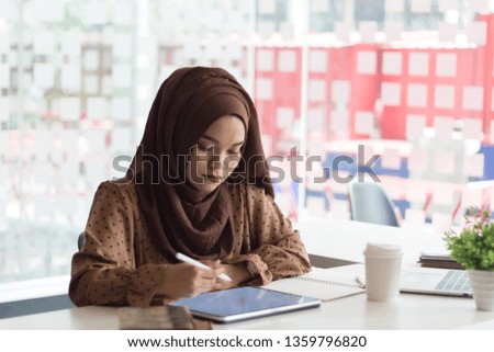 Young asian muslim women working with tablet.