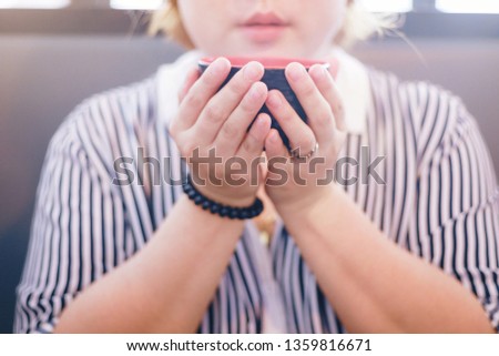 Closeup image of Young woman holding and drinking hot coffee or hot tea with feeling good. refreshing moment.