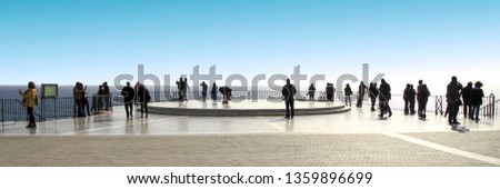Silhouettes of unrecognizable tourists strolling by gazebo facing the sea, tourist in the viewpoint of the balcony of Europe, Nerja, Málaga, Andalucía, spain, Photo with space for advertising,